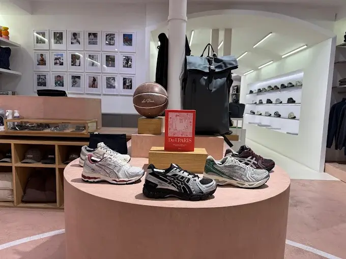 Podium de sneakers Asics en vitrine dans la boutique Ayumi Paris — ambiance showroom minimaliste