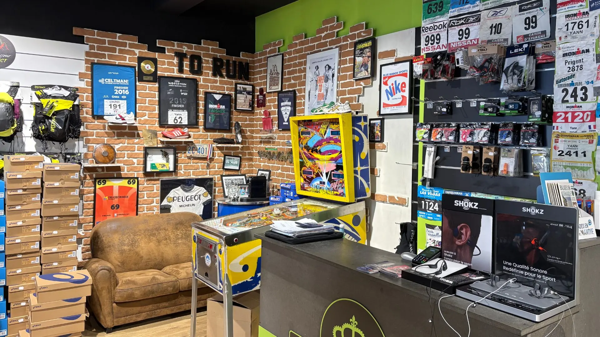 Mur de dossards de course chez Endurance Store Versailles — l'exp&eacute;rience terrain de Yann