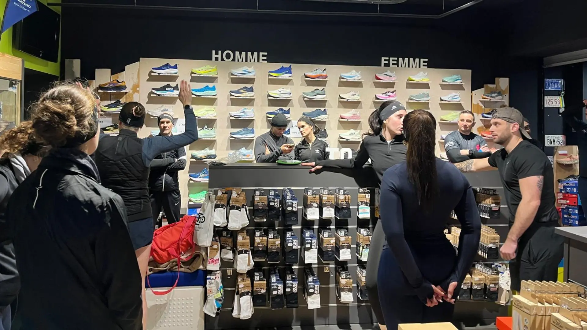 Session de testing en boutique Endurance Store Versailles — clients devant le mur de chaussures