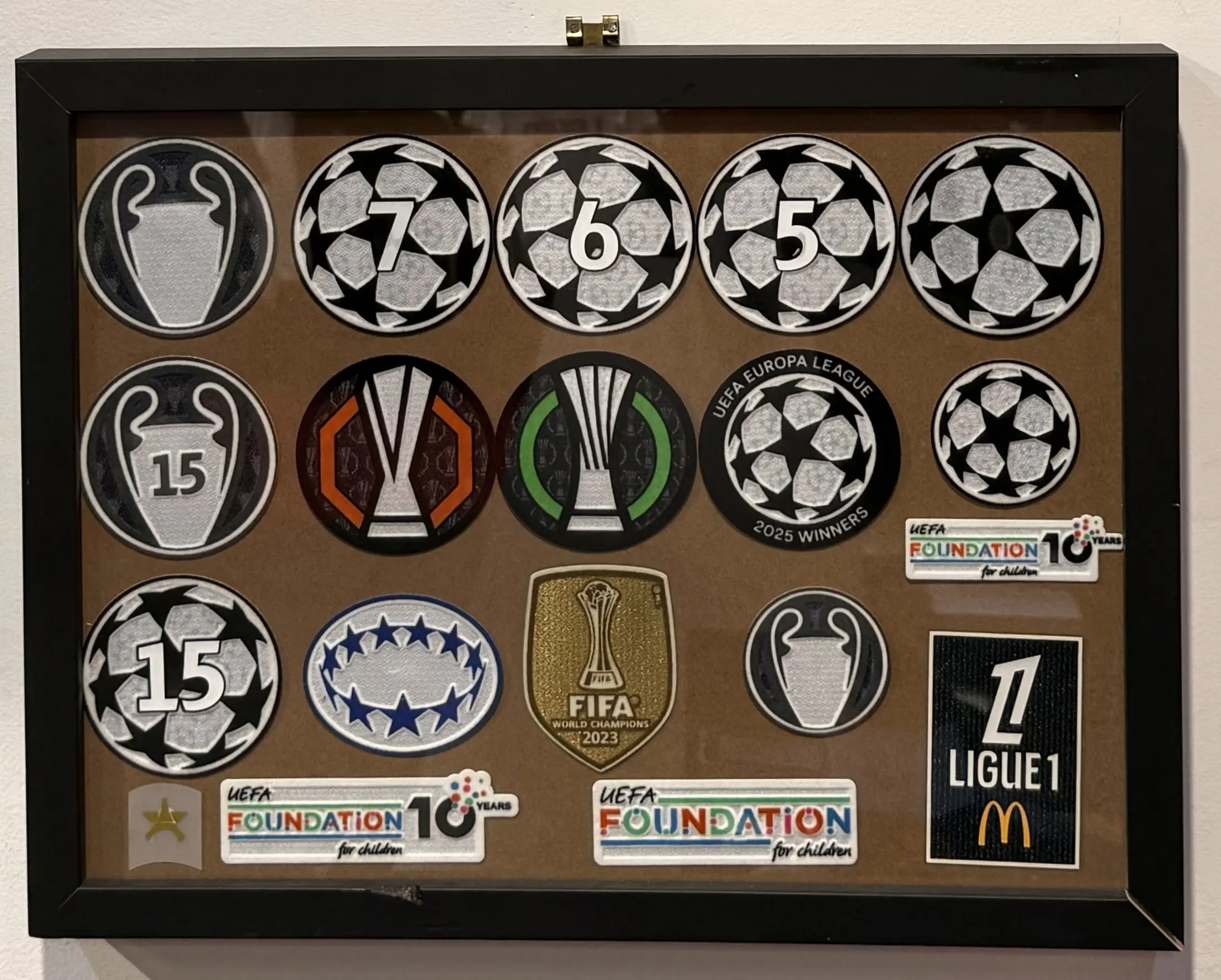 Monter med officiella badges och patches fr&aring;n Foot-Store — UEFA Champions League, Europa League, FIFA World Champions, Ligue 1