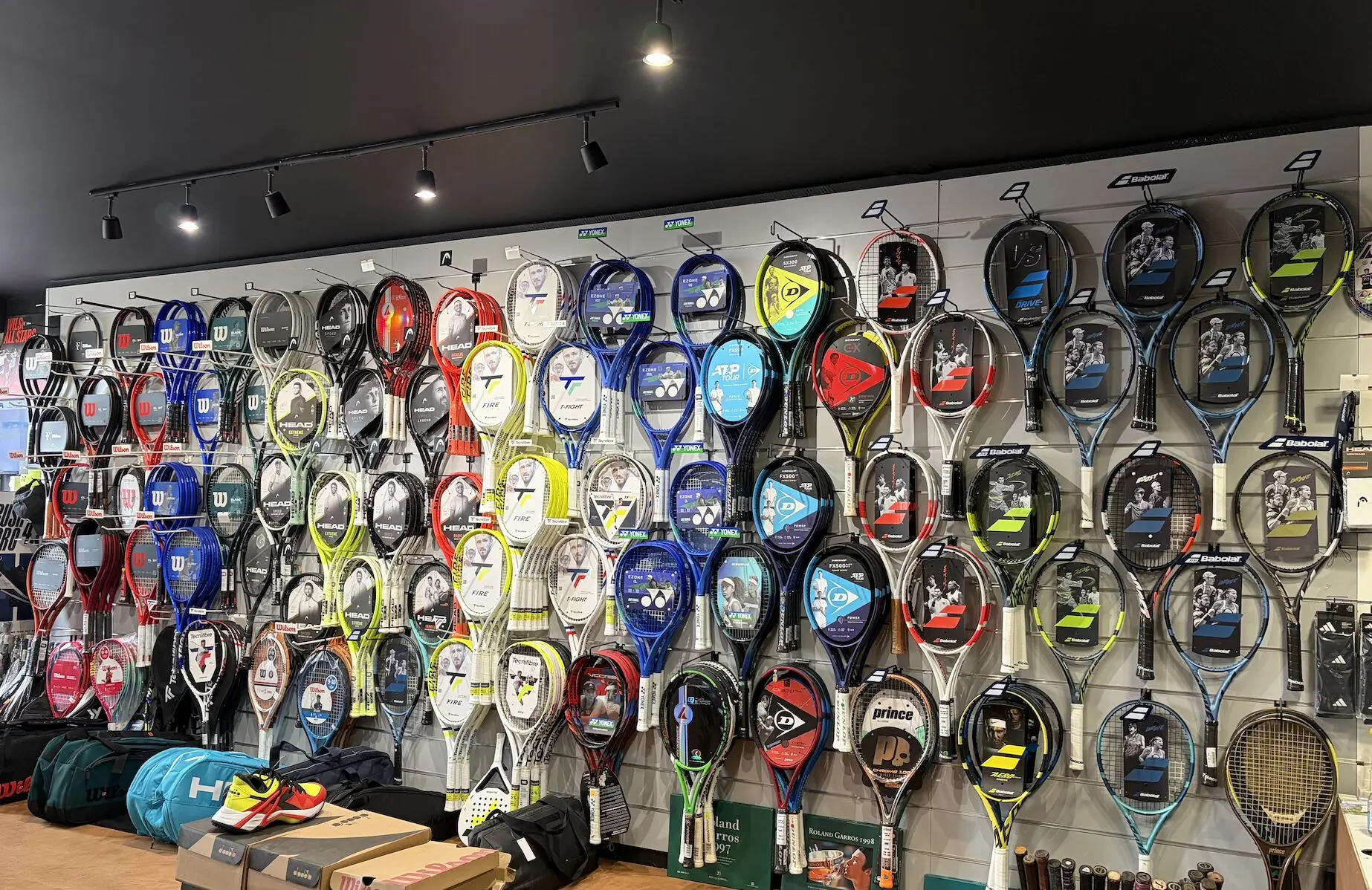 Mur entier de raquettes de tennis dans la boutique Smash Expert — Wilson, Babolat, Head, Yonex